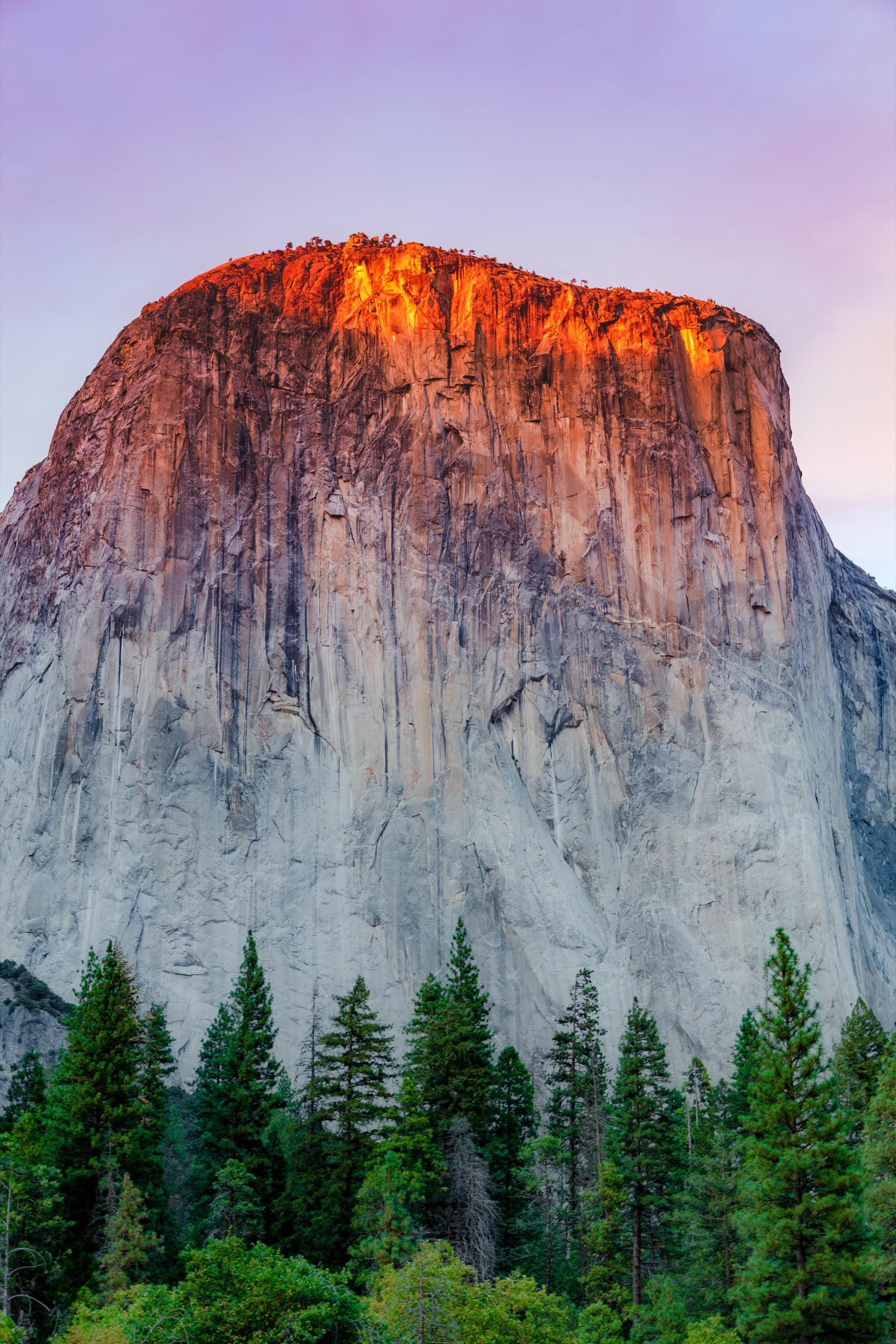 La pared de El Capitán en vertical, con la cima encendida de naranja en los últimos minutos de sol.